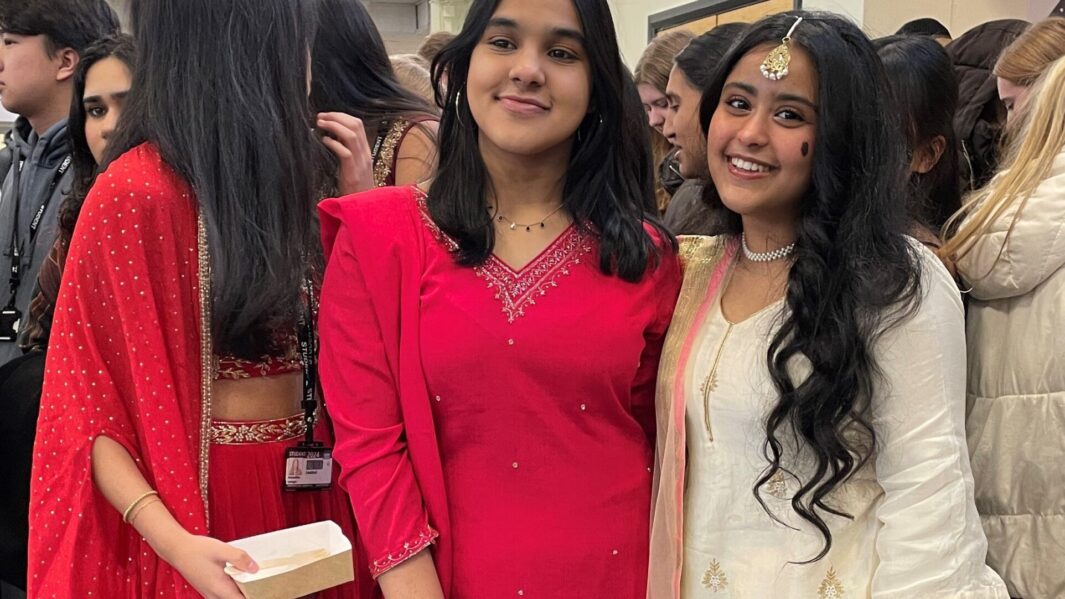 Two female students dressed in Asian cultural clothing smile on Cultural Appreciation Day 2024.