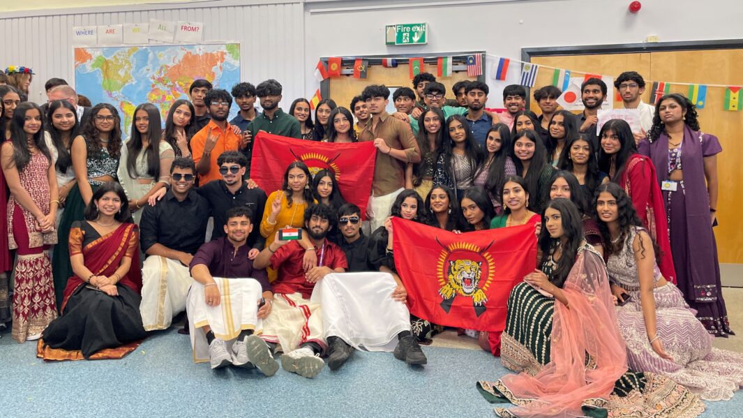 Group of students from Carmel College's South Asian society dressed in South Asian cultural clothing pose together with Tamil Eelam flag.