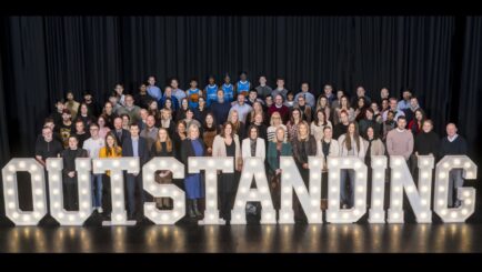 Staff and students stood with the outstanding sign