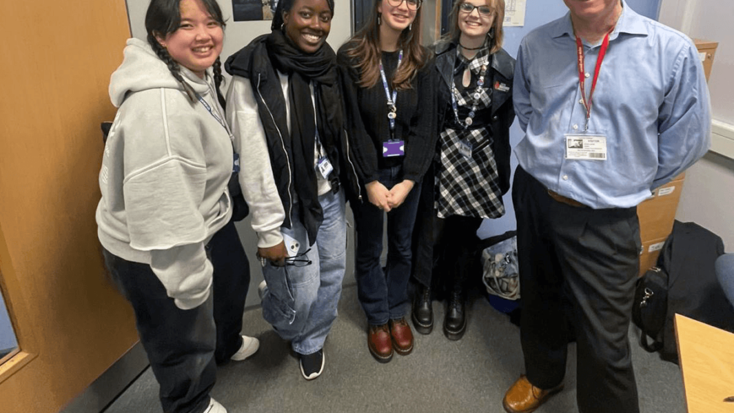 Four female Carmel College students take group picture with David Laven.