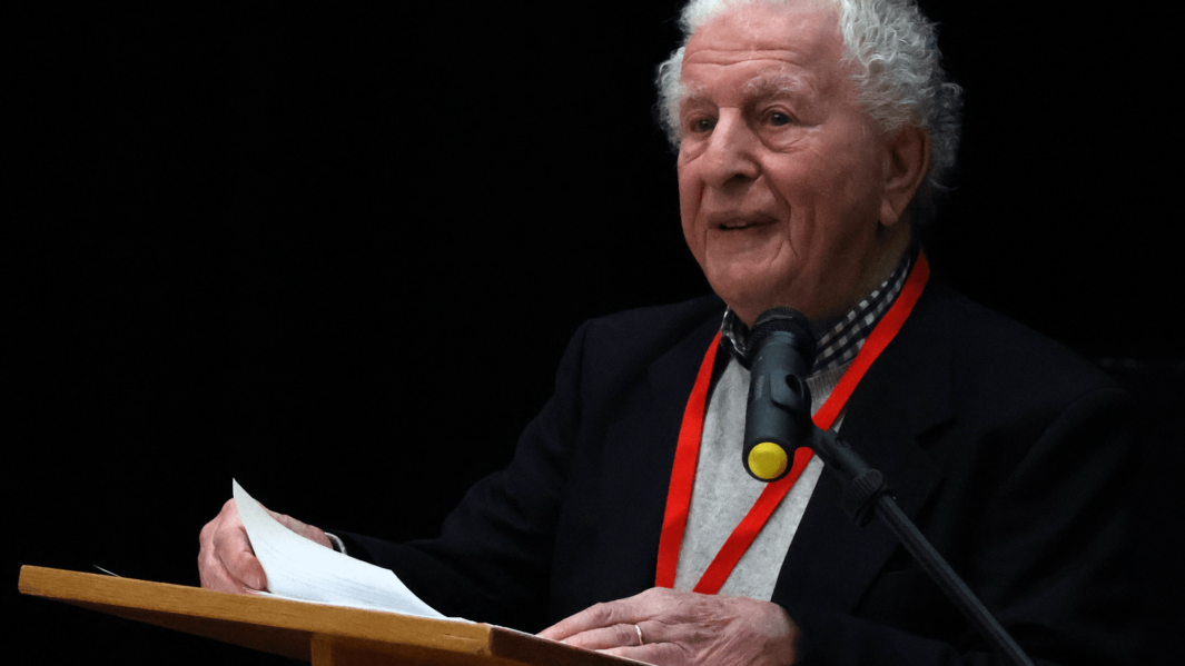 Holocaust survivor Harry Kessler delivers moving testimony at podium to Carmel staff and students.