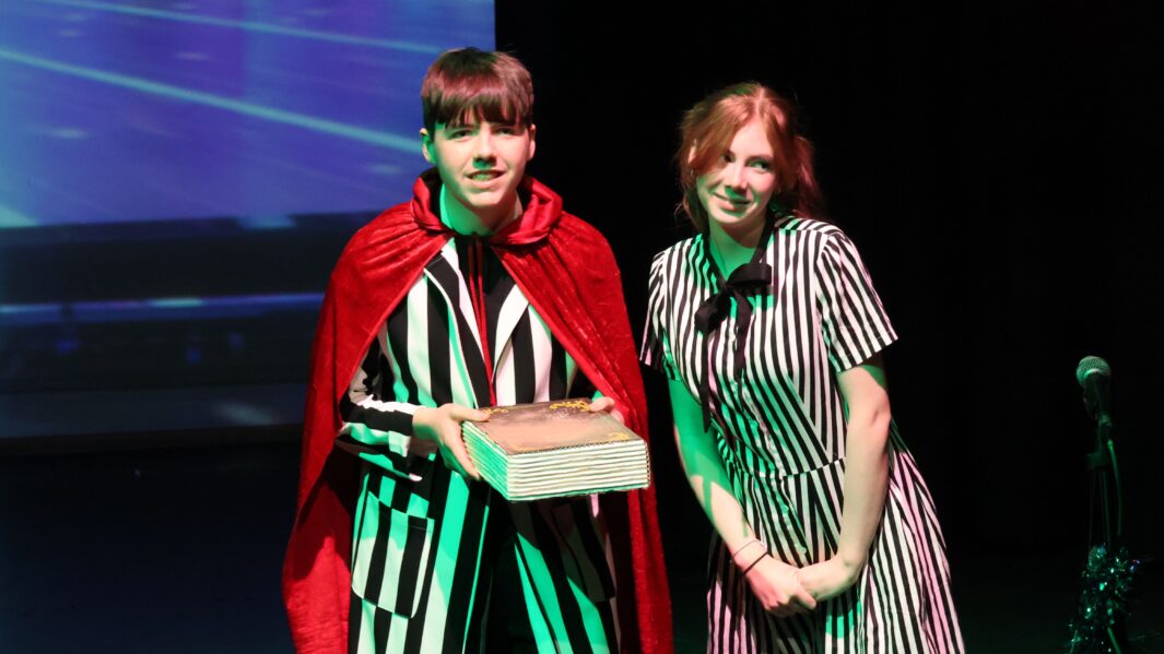 Carmel College's Christmas Pantomime villains pose holding book.
