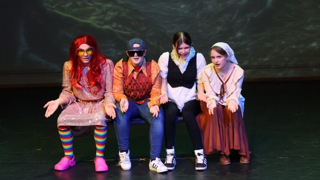 BTEC Performing Arts students sat on bench as part of Christmas Panto 2024.