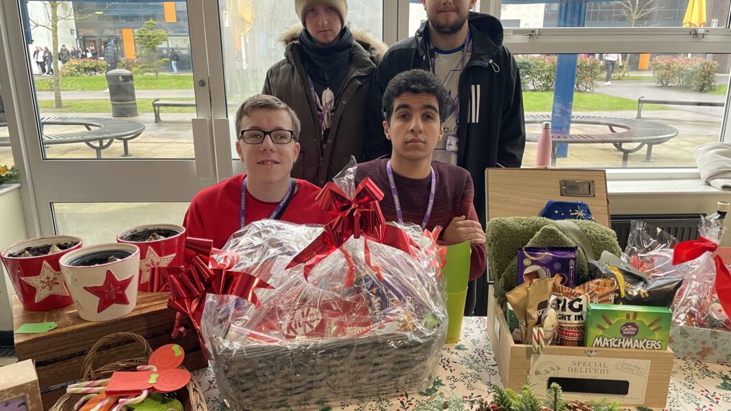 Four Carmel College Foundation Learning students man stall at Carmel's 2024 Christmas Market.