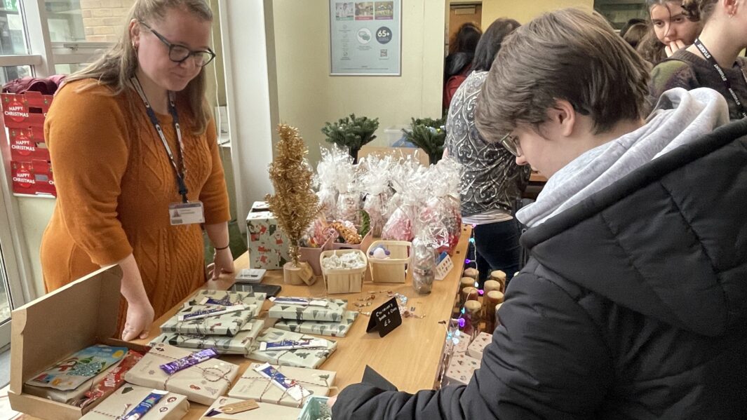 Student holding handmade craft at stall at Carmel Christmas AMrket 2024.