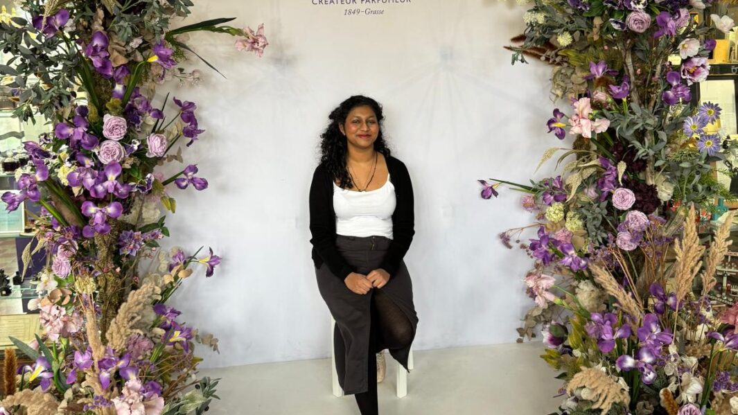 A students at the entrance of a floral arrangement at a restaurant