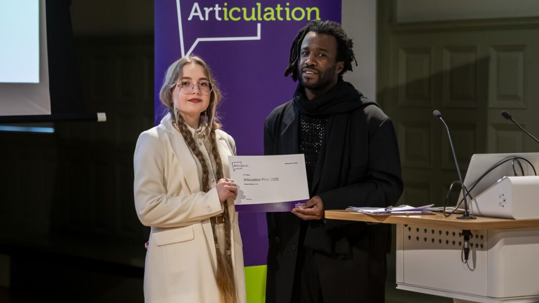 Female student stood with certificate posing with male