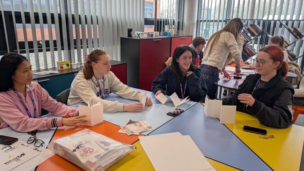 students working at desks on artwork
