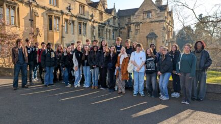 A large group of students stood outside at New College, Oxford
