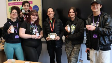 Claire Cockburn stood with students either side of her holding healthy eating products