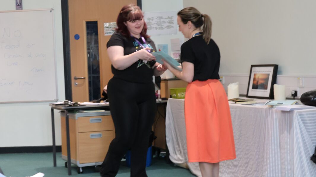 student hand certificate from teacher