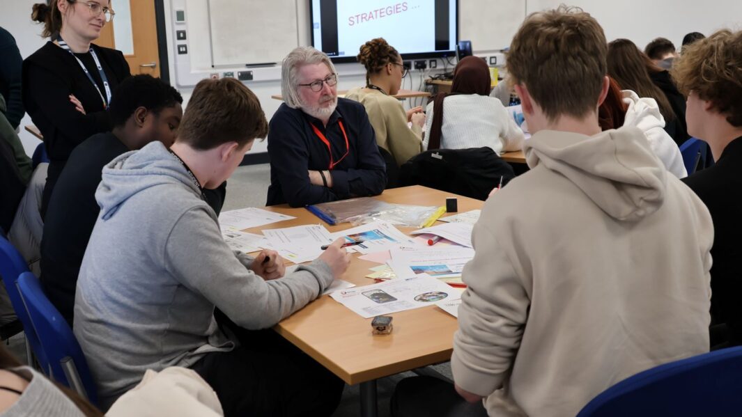 A group of maths students at a desk with Martin Bamber