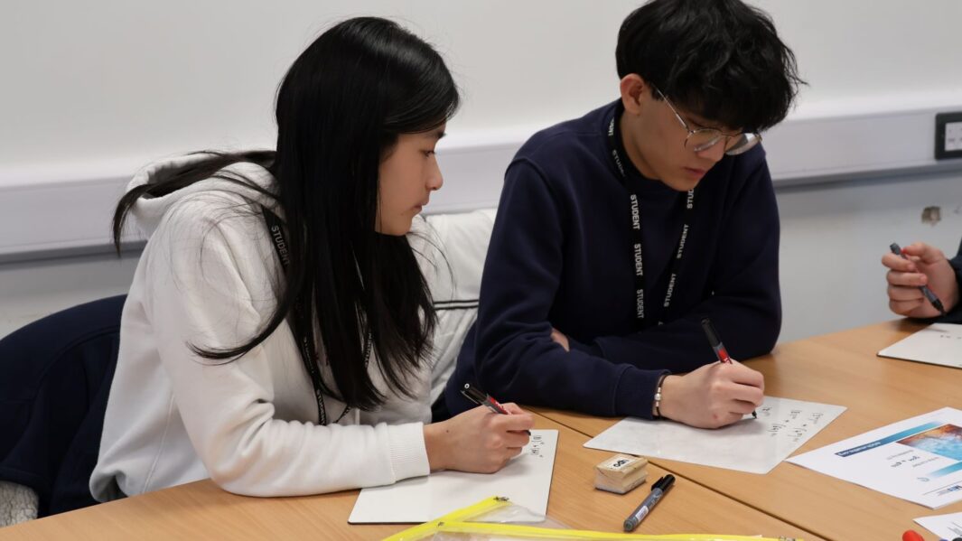 a male and female student at a desk in a maths workshop