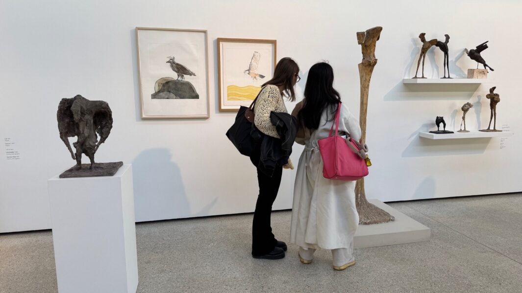 two female students looking at art work