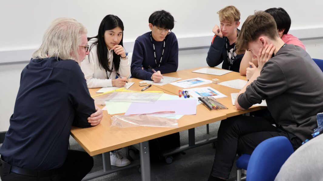 A group of maths students at a desk with Martin Bamber