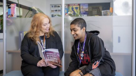 Female Careers Teacher sat on bench, talking to a student