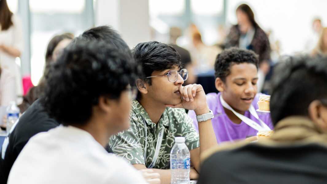 Side profile of student thinking with hand near mouth
