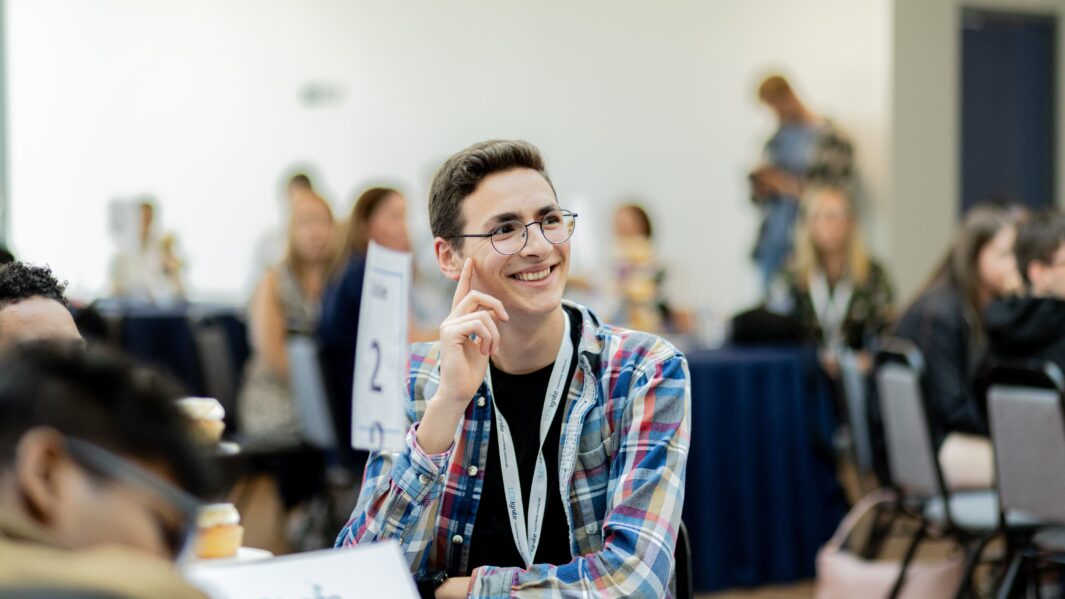 Image of a male student smiling sat at a table