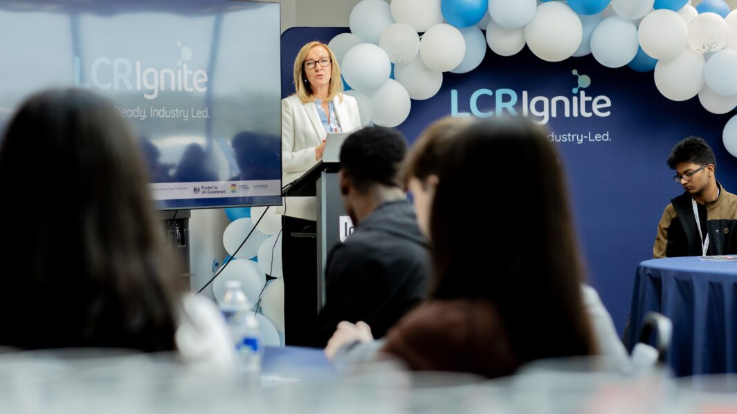 Female giving a speech to a room full of students