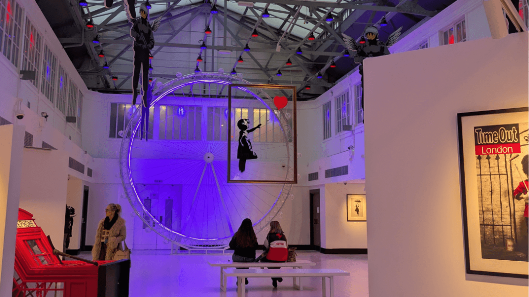 two female students sat on a bench in an art gallery in London
