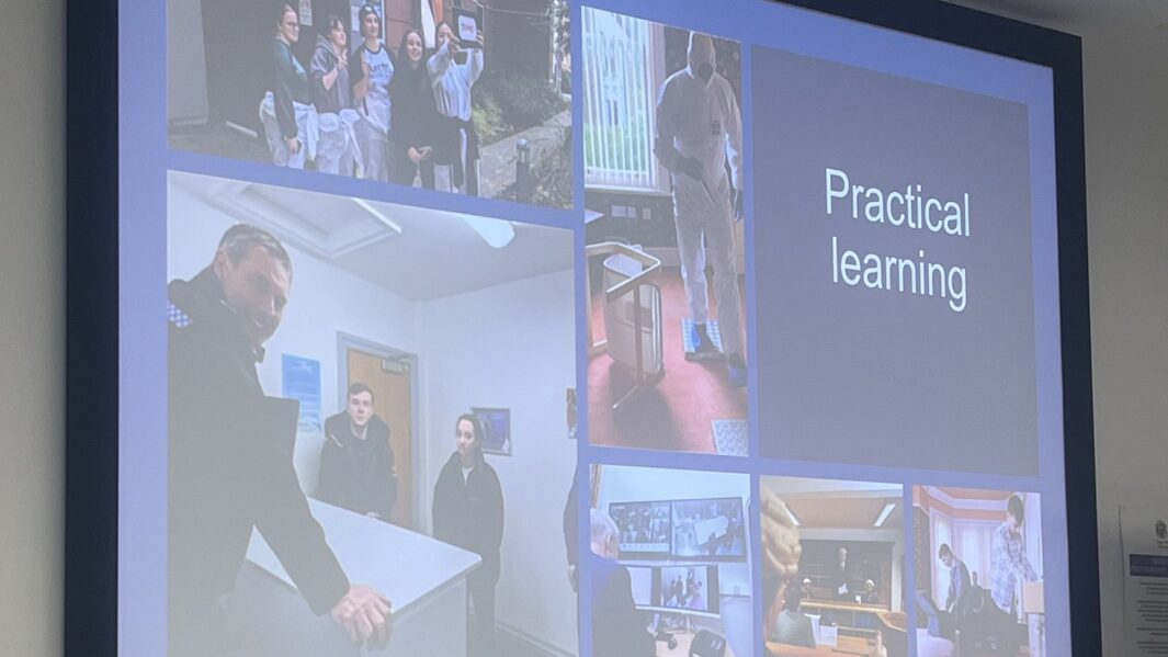 Digital display board projects 'Practical Learning' slide on blue background with pictures of Edge Hill University's 'Crime Scene Investigation' experience.