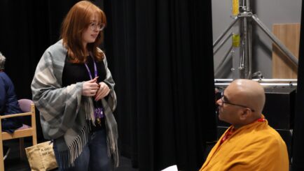 A female student speaking to a male religious leader