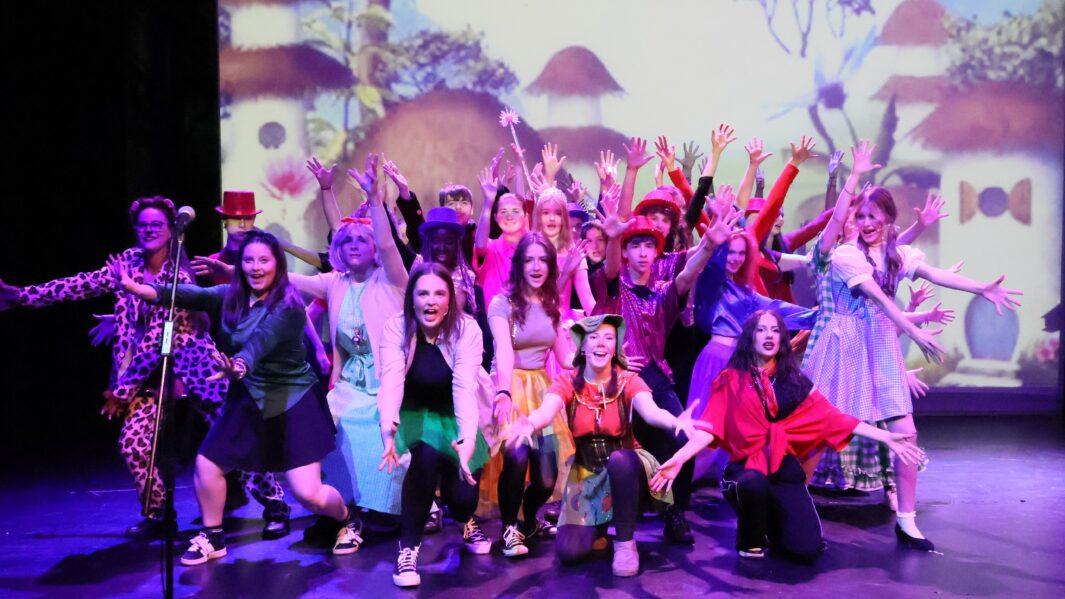 A large group of students dressed up on stage in the Wizard of Oz panto