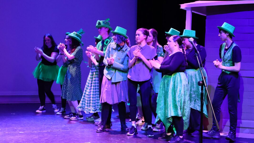 A large group of students dressed up on stage in the Wizard of Oz panto