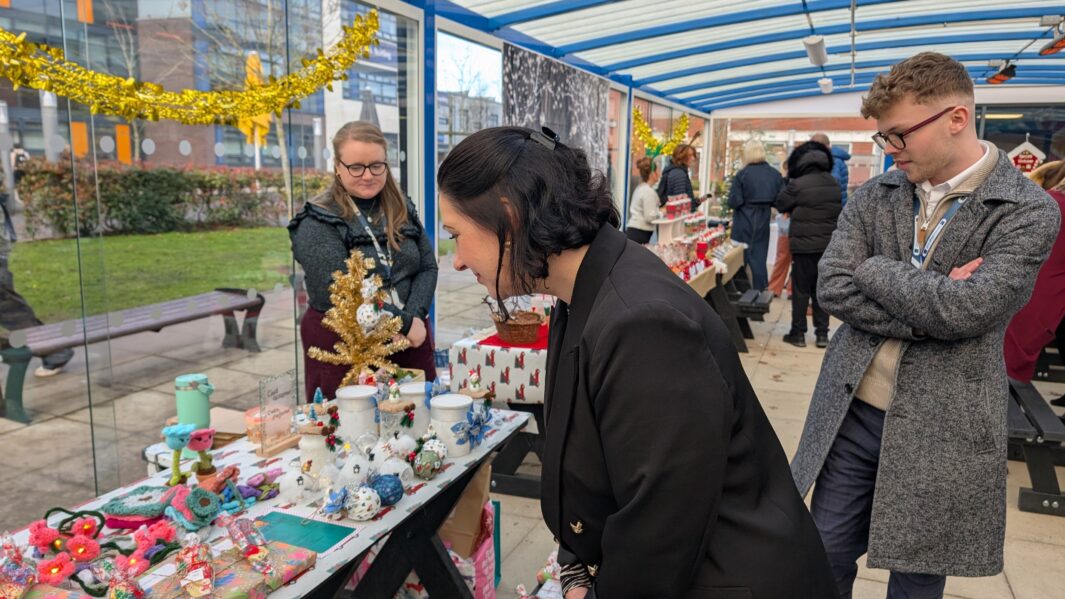 Carmel xmas market with a female member of staff looking at a stall