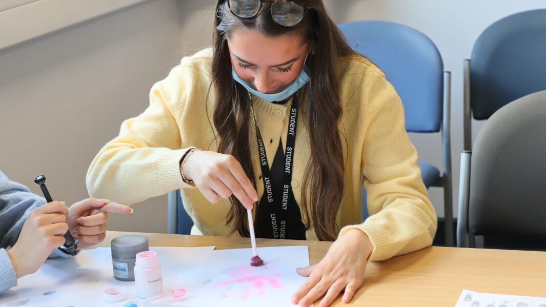 female student working in the Criminology classroom with face masks on looking at evidence