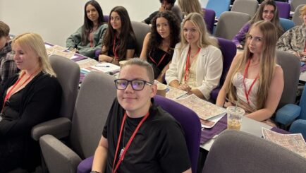 A group of students say in a lecture theatre