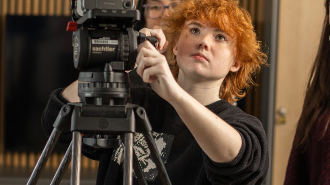 Female student using camera equipment
