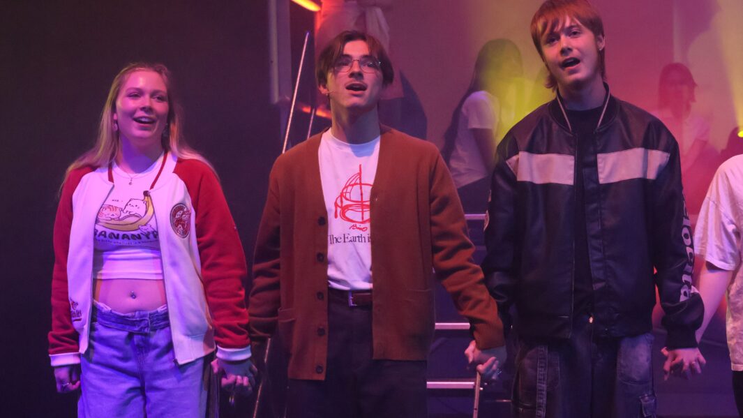 2 boys and a girl on stage in a production