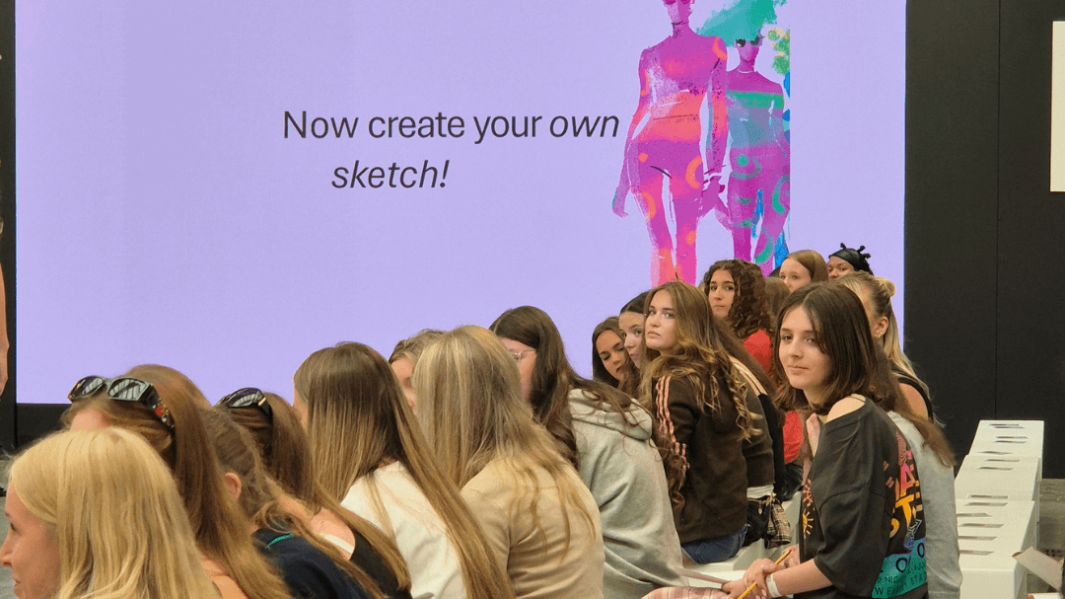 shows people sat along side the runway, with s sign saying sketch what you see