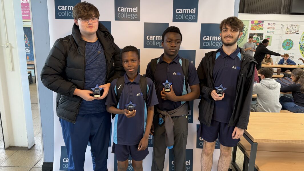 students in school uniform stood holding trophies