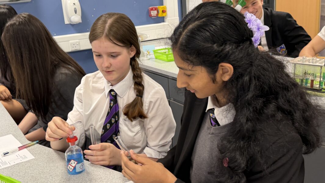 Two girls in school uniform working at a desk