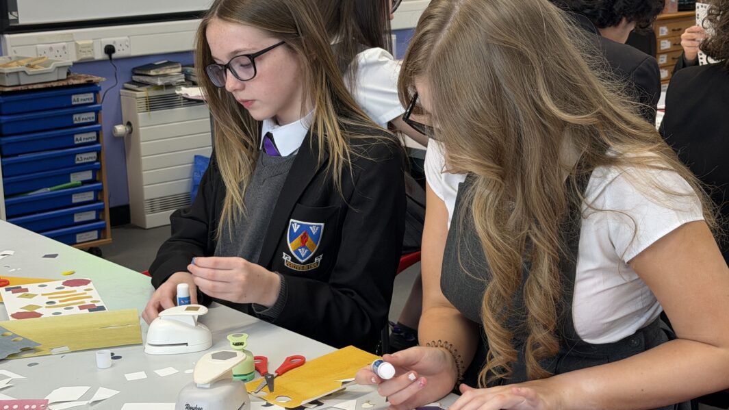 Two girls in school uniform working in an art class