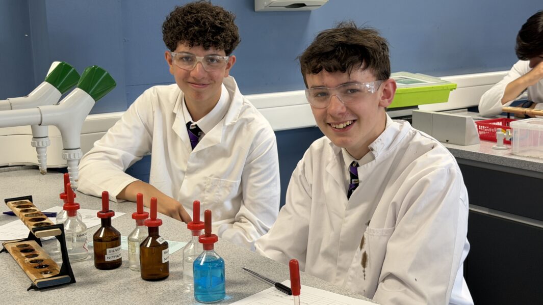 Two boys in lab coats working in a lab at Carmel College