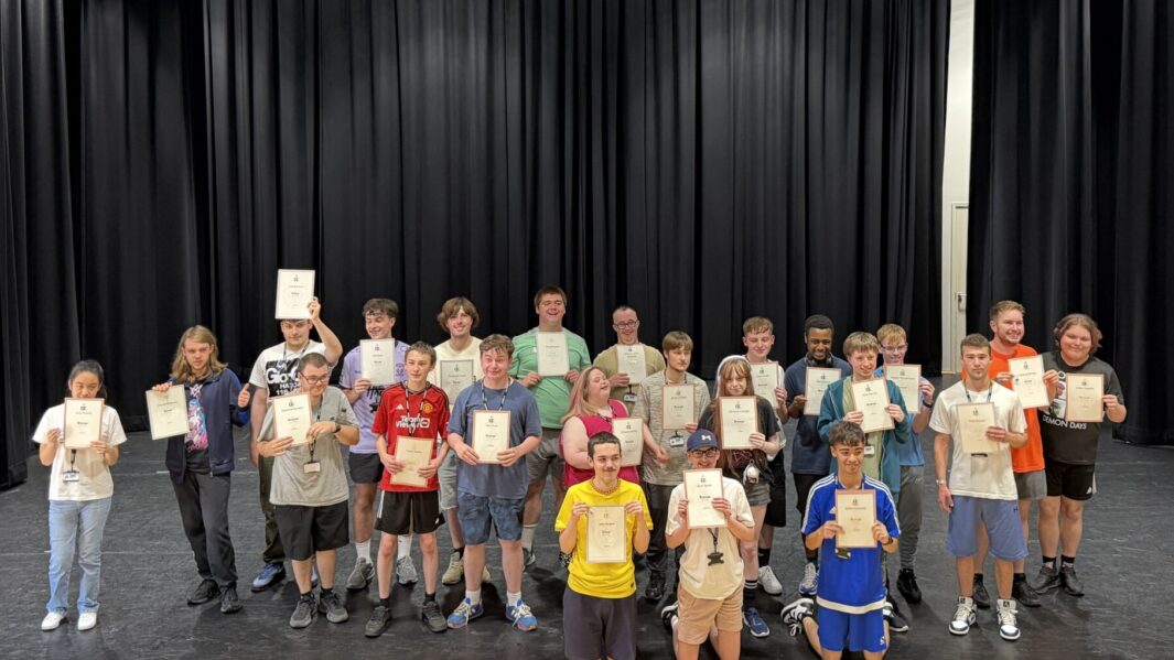 Foundation Learning students holding up their DOFE awards looking happy and proud.
