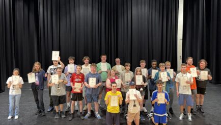 Foundation Learning students holding up their DOFE awards looking happy and proud.