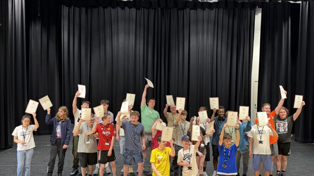 Foundation Learning students holding up their DOFE awards looking happy and proud.