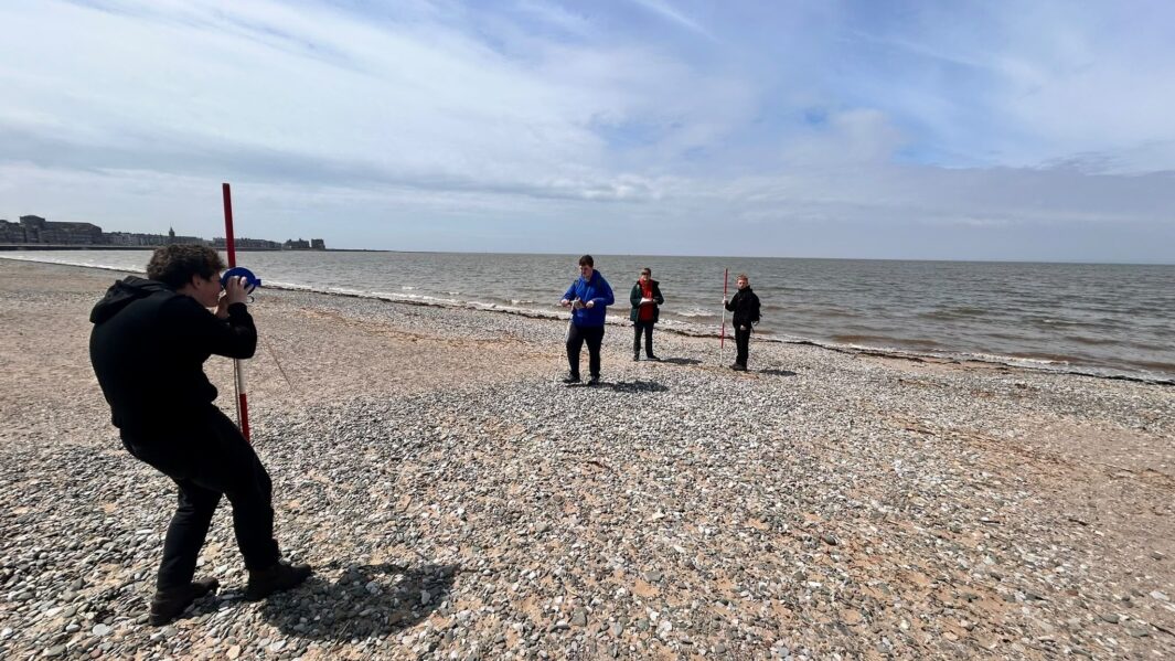 students doing some geography work on the beach
