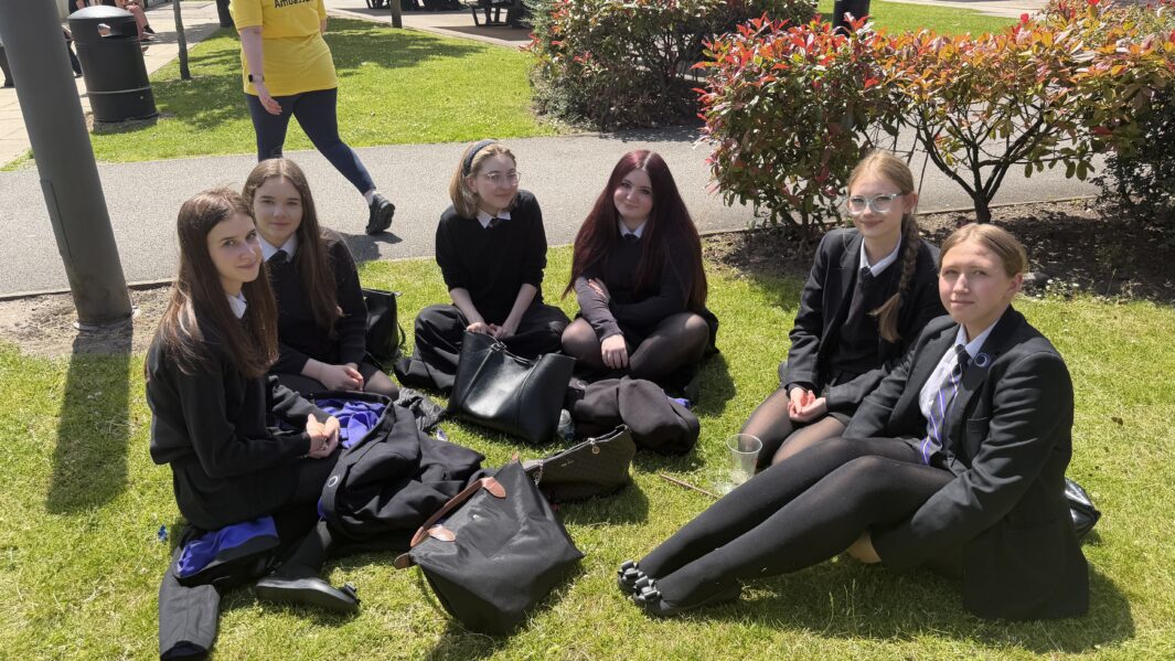 A group of students sat on grass