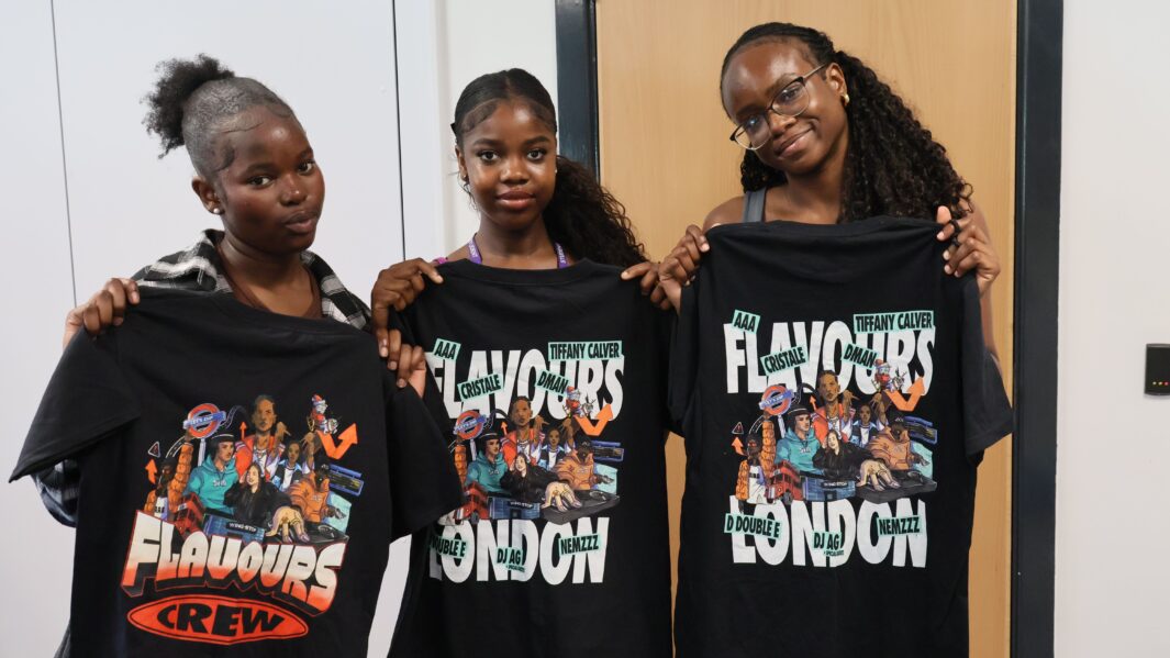 three students holding up the free merch they had been gifted from faye