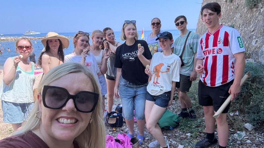 group image of students and teachers on the beach