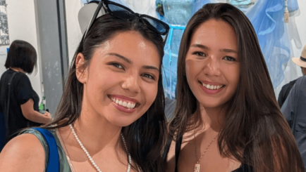 two students enjoying themselves looking happy at art exhibtion