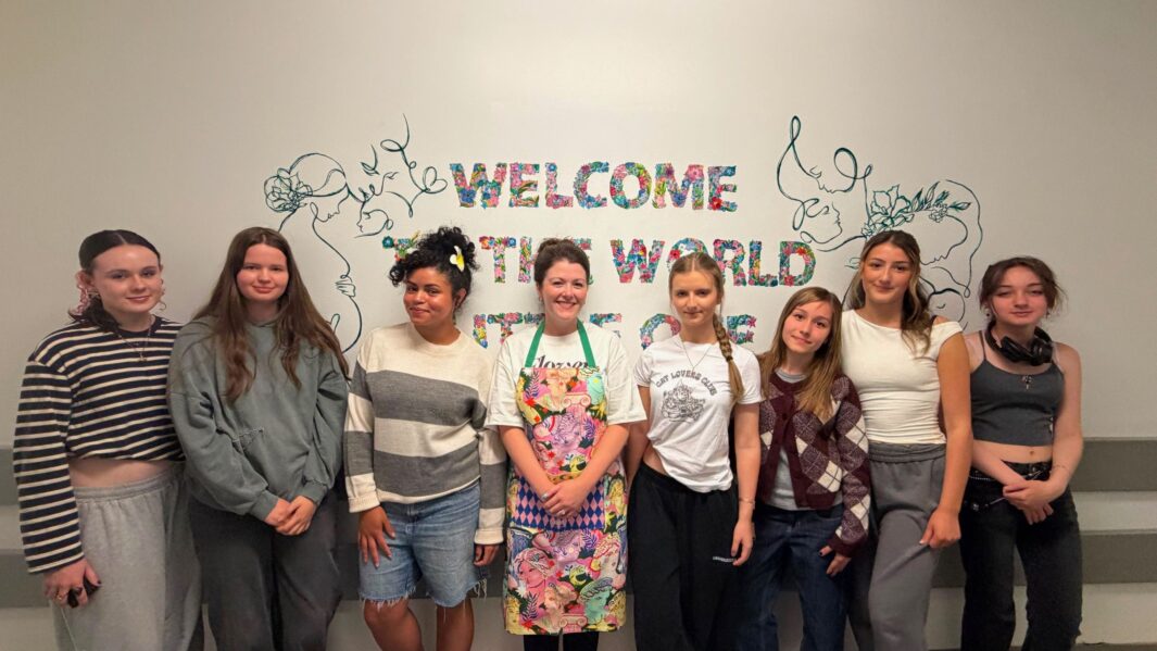 Teacher Melissa and her students infornt of their artwork